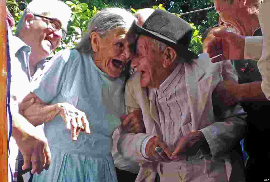 Pria lansia Anacleto Escobar (kanan), seorang pahlawan perang Paraguay, bersama isterinya Cayetana Roman, tersenyum gembira merayakan HUT ke-100 Escobar di mana ia mendapatkan hadiah sebuah rumah di kota Neembucu.