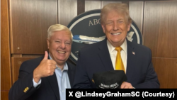 سناتور گراهام در کنار دونالد ترامپ رئیس جمهوری آمریکا کلاهی در دست دارند که روی آن نوشته: «عظمت را دوباره به ایران بازگردانیم» 