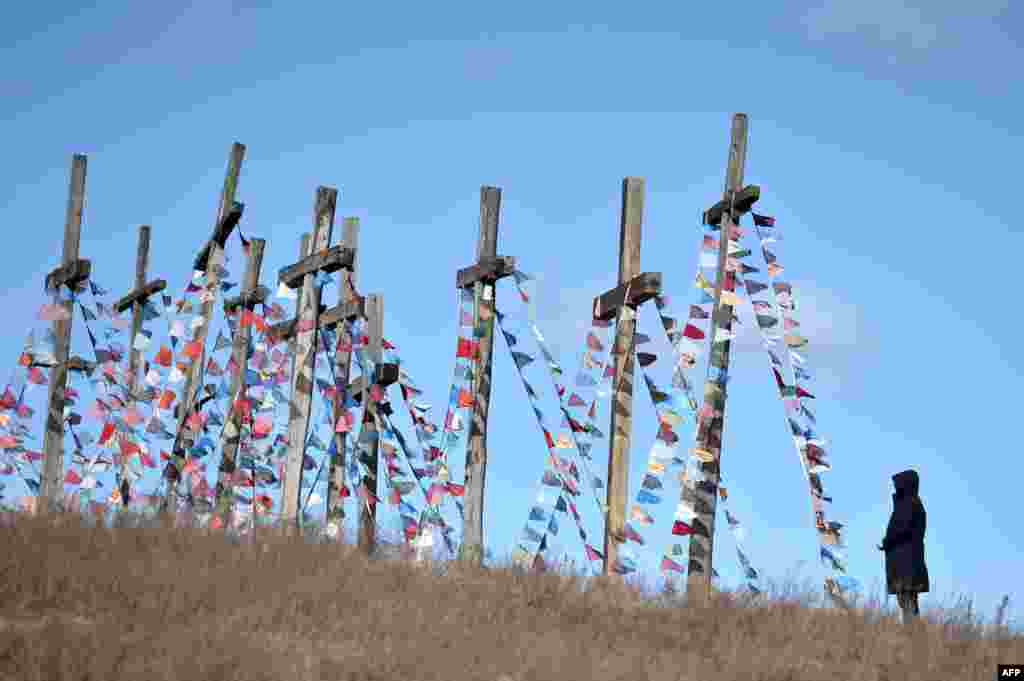 Un hombre se para frente a cruces gigantes el 5 de abril de 2020 en la ciudad de Achmiany, a unos 130 km al noroeste de Minsk, durante las celebraciones del Domingo de Ramos que marcan la semana antes de Pascua.