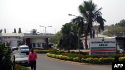 FILE - A man walk past signage for the National Hospital in Abuja, Nigeria, Jan. 14, 2016.