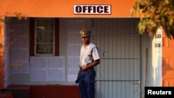 FILE - A police officer keeps watch as locals cast their vote during the Zimbabwe general elections in Kwekwe, outside Harare, Zimbabwe, on August 23, 2023. 