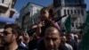 Palestinska djevojčica sa plastičnom puškom na očevima ramenima tokom protesta u Ramali na Zapadnoj obali (Foto: AP/Nasser Nasser)