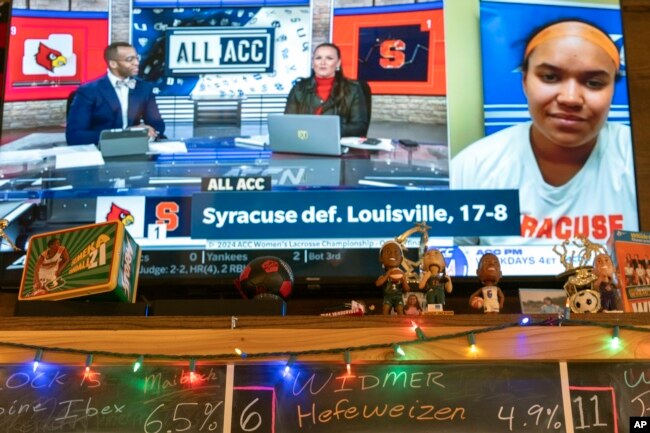 A TV at The Sports Bra sports bar in Portland, Ore., displays Syracuse's Emma Ward on ACC Network's "All ACC" after an NCAA college lacrosse game on Wednesday, April 24, 2024. (AP Photo/Jenny Kane)