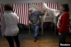 FILE - A voter exits a voting booth after filling out his ballot in the U.S. presidential primary election in the village of Groveton, New Hampshire, Feb. 9, 2016.