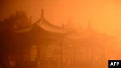 FILE - Pagodas are seen on a polluted day in Hohhot, north China's Inner Mongolia region. The agreement goes into force when joined by at least 55 nations that produce a total of 55 percent of global emissions.