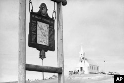 This undated file photo shows the historical marker commemorating the Wounded Knee Massacre of 1890 on the road near the Sacred Heart Catholic Church in Wounded Knee, S.D