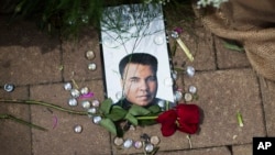 A rose lays next to an image of Muhammad Ali at a makeshift memorial at the Muhammad Ali Center in Louisville, Kentucky, June 5, 2016.