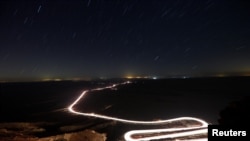 Mobil-mobil melaju melalui Ramon Crater saat hujan meteor Perseid di dekat Kota Mitzpe Ramon, bagian Selatan Israel, 12 Agustus 2018.