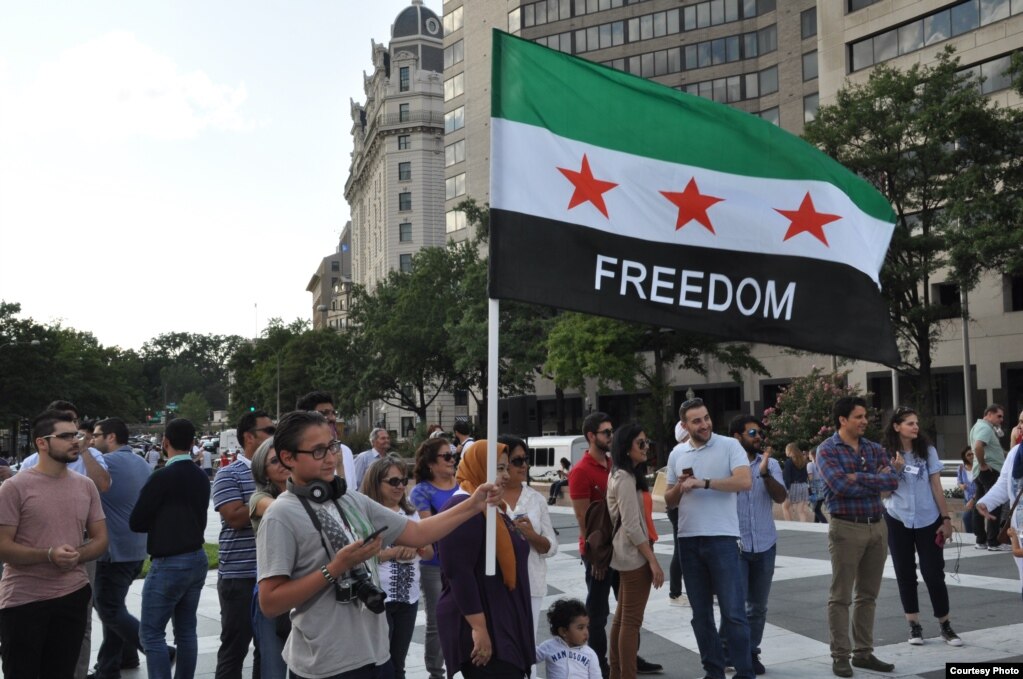 A man carries the Syrian opposition flag during Syria Fest in Washington, Sept. 3, 2017. (Photo courtesy of Rabah Seba)
