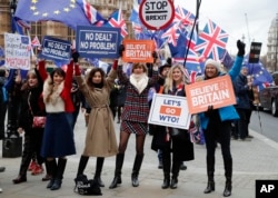 Leavers hold up signs next to pro-European demonstrators protesting opposite the Houses of Parliament in London, Jan. 15, 2019.