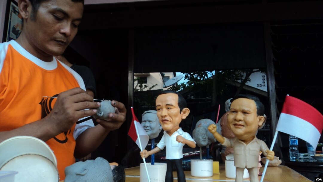 Agus Wiryawan, seorang pemahat patung dari Solo, Jawa Tengah, dengan hasil karyanya yang menggambarkan kedua calon presiden dalam Pemilu Indonesia 2014 (Foto: VOA/Yudha)