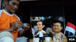 Agus Wiryawan, seorang pemahat patung dari Solo, Jawa Tengah, dengan hasil karyanya yang menggambarkan kedua calon presiden dalam Pemilu Indonesia 2014 (Foto: VOA/Yudha)