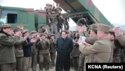 North Korean leader Kim Jong Un, center, guides the test fire of a new multiple launch rocket system in this undated photo released by North Korea's Korean Central News Agency (KCNA) in Pyongyang, March 4, 2016. 