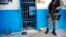 Un officier de police est à l'extérieur d'une cellule où a eu lieu la mutinerie, à Arcahaiea, Haïti, le 22 octobre 2016.