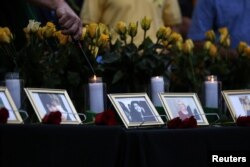 Candles are lit behind images of the victims killed in a shooting at Santa Fe High School during a vigil in League City, Texas, May 20, 2018.