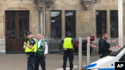 Des policiers néerlandais près de la scène d'une attaque à l'arme blanche près de la gare centrale quotidienne à Amsterdam, aux Pays-Bas, vendredi 31 août 2018.