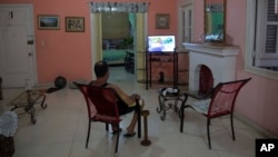 A homeowner sits in his living room at his home with rooms for rent in Havana, Cuba, April 1, 2015.