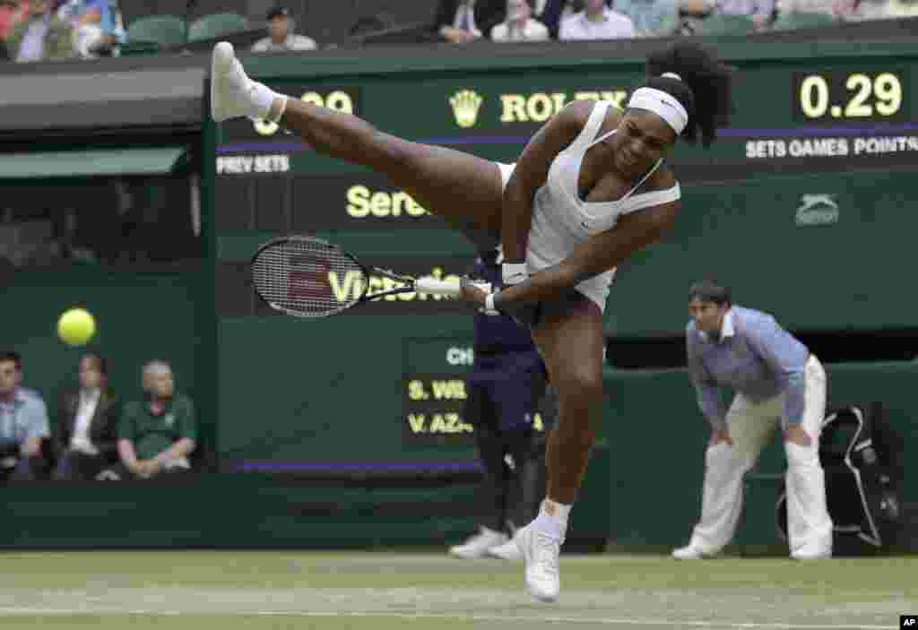 Tay vợt Serena Williams của Mỹ đánh trả bóng cho Victoria Azarenka của Belarus trong một trận đấu tại giải vô địch tennis All England Lawn diễn ra tại Wimbledon, London.