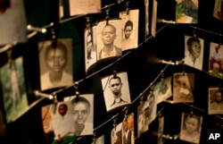 FILE - Family photographs of some of those who died hang in a display in the Kigali Genocide Memorial Centre in Kigali, Rwanda, April 5, 2014.