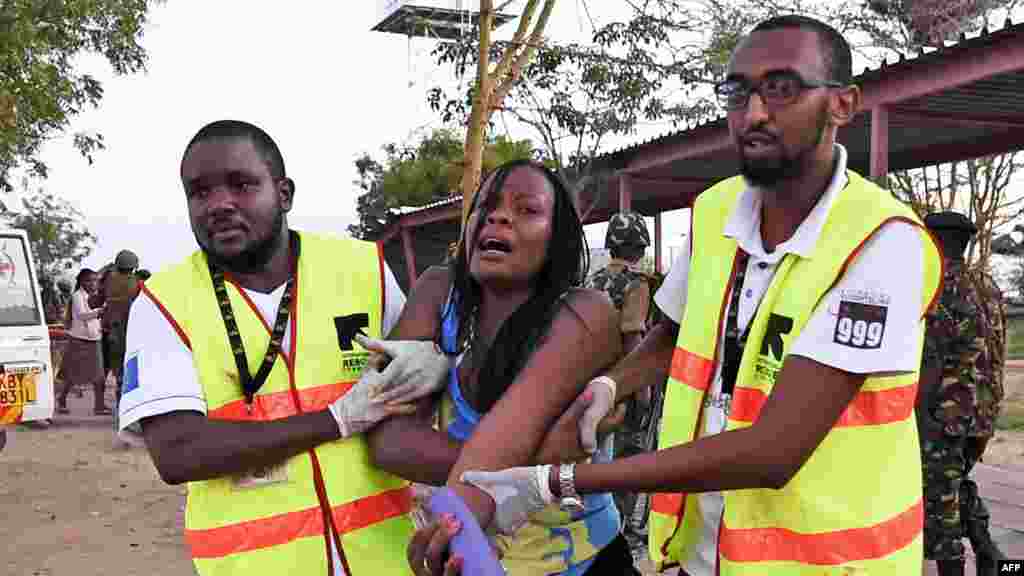 Petugas paramedis membatu mahasiswi yang terluka dalam serangan oleh pria-pria bersenjata dari kelompok militan al-Shabab di Garissa University College (2/4).&nbsp;​(AFP/Carl de Souza)