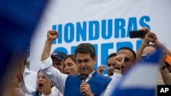 Prezidan aktyèèl peyi Honduras la, Juan Orlando Hernandez, ak men dwat li alè pandan yon rankont ak patizan li yo Tegucigalpa, Honduras, 7 desanm 2017.