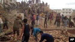 在尼泊尔首都加德满都，强烈地震发生后，志愿者协助救援人员抢救瓦砾下可能生还的人。摄于2015年4月25 日，星期六