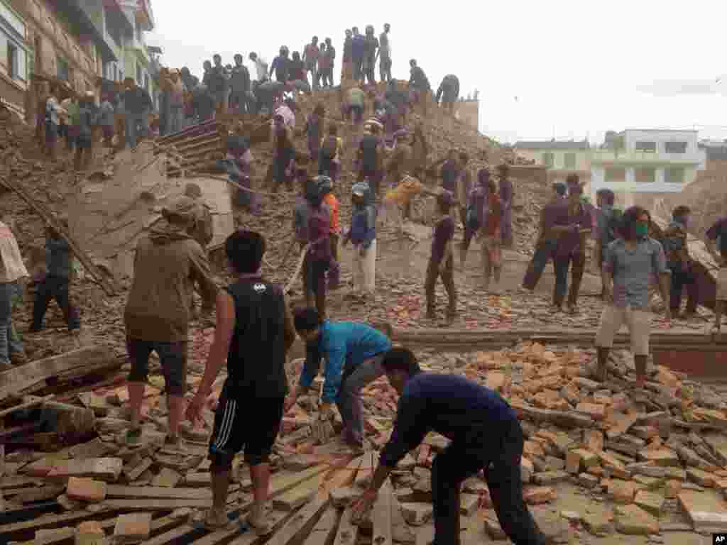 Volunteers help with rescue work at the site of a building that collapsed after an earthquake in Kathmandu, Nepal, April 25, 2015.