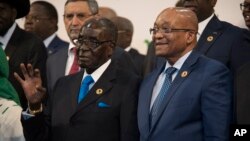 Zimbabwean president and chair of the African Union Summit Robert Mugabe (l) stands next to South African president Jacob Zuma during a photo op at the AU summit in Johannesburg, June 14 2015.