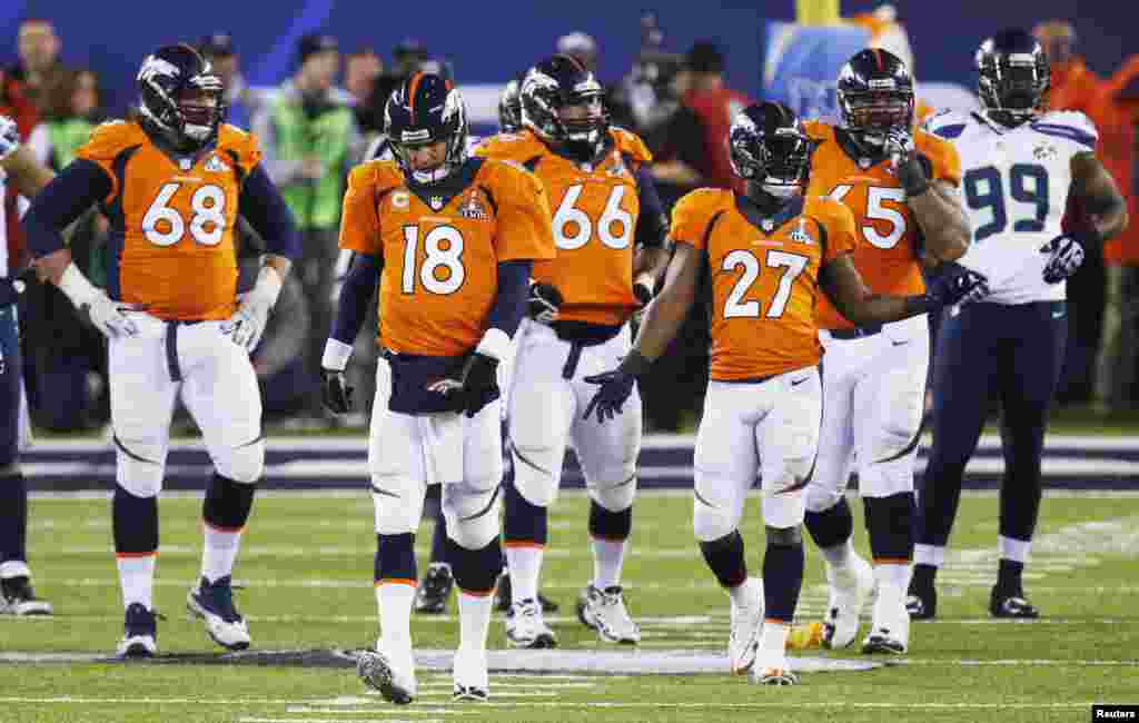 Denver Broncos quarterback Peyton Manning walks back to a huddle with teammates after a penalty call against the Seattle Seahawks, Fe. 2, 1014.