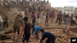 Volunteers help with rescue work at the site of a building that collapsed after an earthquake in Kathmandu, Nepal, Saturday, April 25, 2015. 