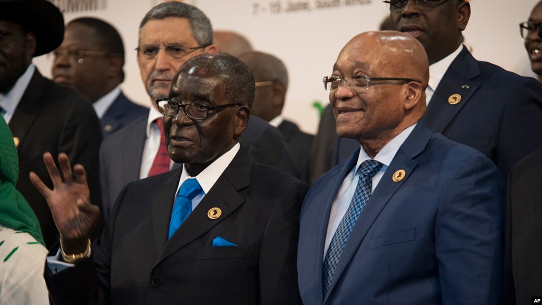 Presiden Zimbabwe dan ketua KTT Uni Afrika Robert Mugabe (kiri) bersama Presiden Afrika Selatan Jacob Zuma dalam sesi foto di KTT Uni Afrika di Johannesburg (14/6). (AP/Shiraaz Mohamed)