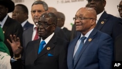 Presiden Zimbabwe dan ketua KTT Uni Afrika Robert Mugabe (kiri) bersama Presiden Afrika Selatan Jacob Zuma dalam sesi foto di KTT Uni Afrika di Johannesburg (14/6). (AP/Shiraaz Mohamed)