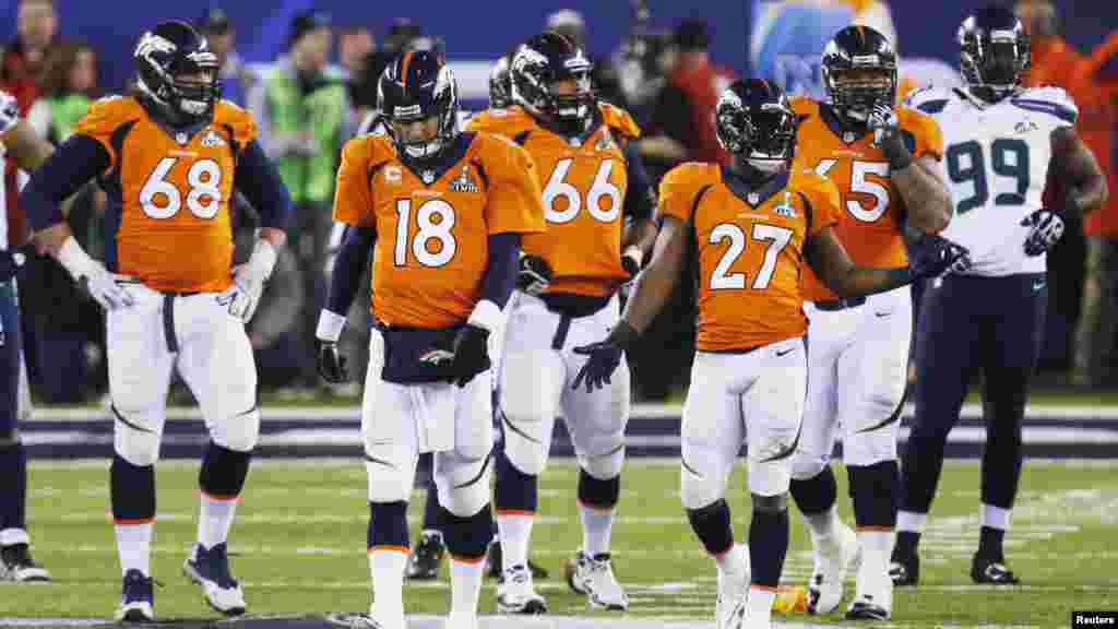 Denver Broncos quarterback Peyton Manning walks back to a huddle with teammates after a penalty call against the Seattle Seahawks.