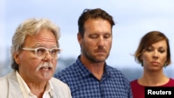 FILE - John Ruszczyk, the father of Justine Damond, speaks as he stands next to his son Jason Ruszczyk and Jason's wife Katarina, during a media conference in Sydney, Dec. 21, 2017.