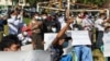 FILE - Protesters shout slogans as they take part in a rally to condemn results of Nov. 8 general election, Nov. 20, 2020, in Yangon, Myanmar.