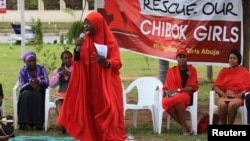 FILE - A member of the Abuja "Bring Back Our Girls" protest group addresses a sit-in demonstration organized by the group at the Unity Fountain in Abuja, Nigeria, June 23, 2014. 