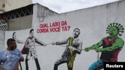 FILE - A man passes graffiti depicting a likeness of Brazilian President Jair Bolsonaro and a coronavirus character engaged in a tug-of-war with health workers, in Sao Paulo, Brazil, June 10, 2020. The text in red reads: "Which side are you on?"
