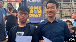 梁继平(右)9月15日与黄之锋一起在纽约时报广场高唱荣光归香港的歌曲。