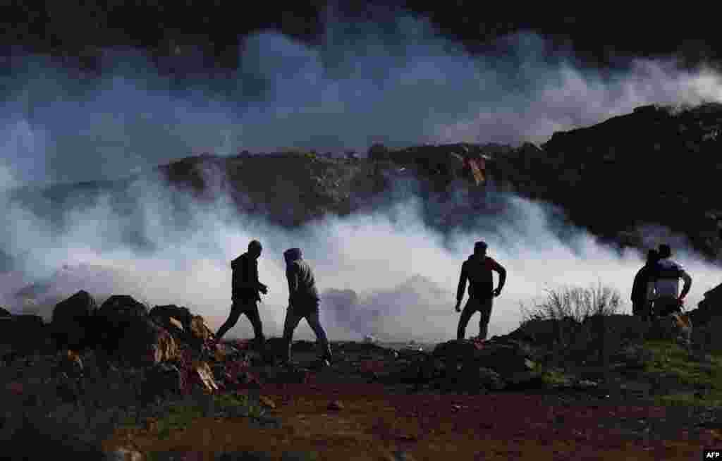 Palestinian demonstrators are surrounded by tear gas smoke launched by Israeli forces during a protest in the north of Ramallah in the Israeli-occupied West Bank. They are protesting the decision by U.S. President Donald Trump to recognize Jerusalem as the capital of Israel.