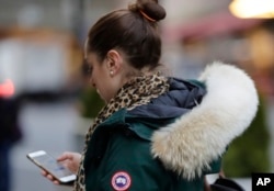 In this Feb. 14, 2019 photo, a woman in New York wears a Canada Goose coat with the hood trimmed in coyote fur. (AP Photo/Frank Franklin II)