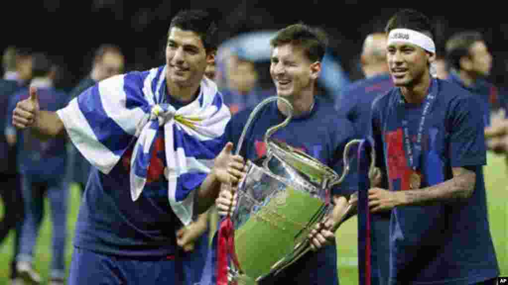 Lionel Messi de Barcelone, au centre, Neymar et Luis Suarez, à gauche, célébre avec le trophée après le match de finale de la Ligue des champions entre la Juventus de Turin et le FC Barcelone au stade olympique de Berlin samedi 6 Juin 2015. Barcelone a remporté le match 3 1.