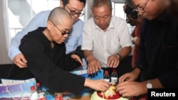 Liu Xia, wife of deceased Chinese Nobel Peace Prize-winning dissident Liu Xiaobo and other relatives attend his sea burial off the coast of Dalian, China, in this photo released by Shenyang Municipal Information Office July 15, 2017. 