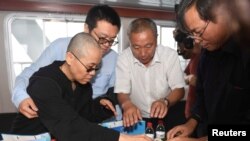 刘晓波遗孀刘霞， 刘晓波大哥刘晓光和弟弟刘晓瑄（右），刘霞弟弟刘晖准备把刘晓波的骨灰撒入大海（2017年7月15日，沈阳市政府提供的图片）。