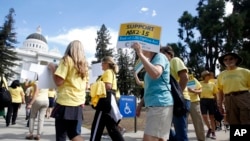 FILE - Activists are seen rallying in support of physician-assisted suicide for the terminally ill at the Capitol in Sacramento, California, Sept. 24, 2015.