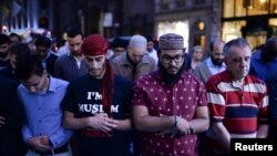 Warga Muslim melakukan shalat Maghrib berjamaah di depan Trump Tower di Manhattan, New York (1/6).