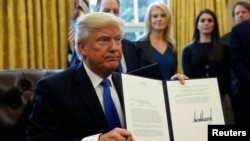 Presiden AS Donald Trump memperlihatkan perintah eksekutif yang telah ditandatangani untuk meneruskan pembangunan jalur pipa Keystone XL (24/1). (Reuters/Kevin Lamarque)