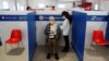 A man receives his third dose of coronavirus disease (COVID-19) vaccine at a Red Cross vaccination centre by Termini, Rome's main train station, as the government discusses more stringent rules for the health pass known as a Green Pass, in Rome, Italy, No