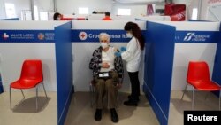 A man receives his third dose of coronavirus disease (COVID-19) vaccine at a Red Cross vaccination centre by Termini, Rome's main train station, as the government discusses more stringent rules for the health pass known as a Green Pass, in Rome, Italy, No