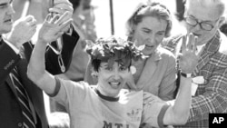 FILE - Rosie Ruiz waves to the crowd after after being announced as winner of the women's division of the Boston Marathon in Boston, April 21, 1980.