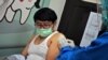 Un trabajador de salud inyecta una vacuna de coronavirus a un voluntario en un centro médico comunitario en Bandung, West Java, Indonesia, el viernes 14 de agosto de 2020.